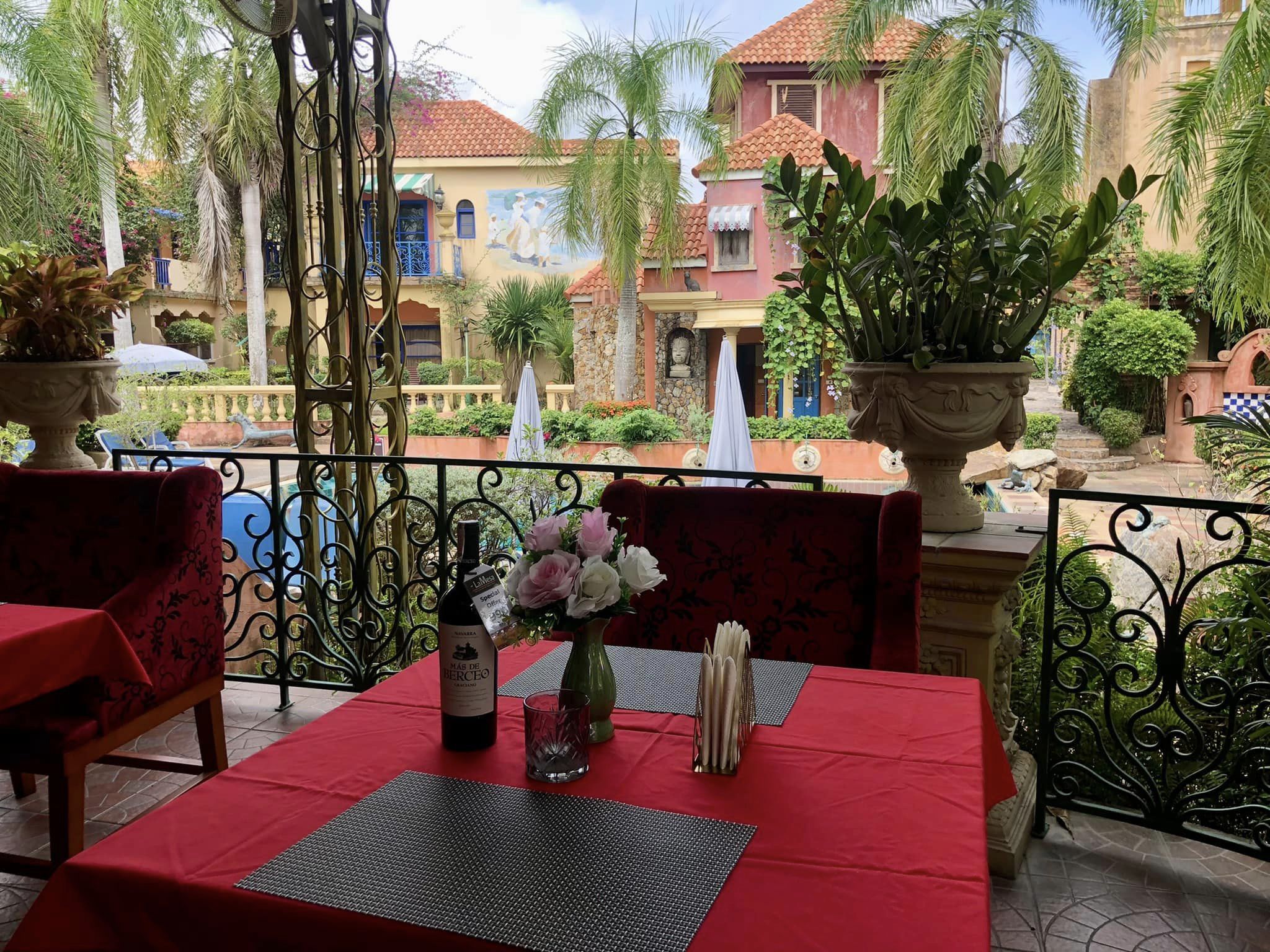 restaurant la mesa terace table with a bottle of wine plants and flowers